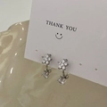 Close-up of silver flower earrings with sparkling square zircon crystals on card - Silver Flower Zirconia Earrings (Gold Plated)