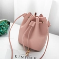 Pink litchi leather bucket bag with gold tassel beads on a white minimalist background - Pink