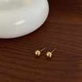 Dettaglio di orecchini a lobo a sfera dorati lucidi su sfondo in ceramica bianca - 8mm / Oro 8mm
