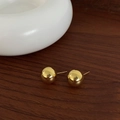 Dettaglio di orecchini a lobo a sfera dorati lucidi su una base in legno scuro - 14mm / Oro 14mm