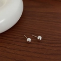 Orecchini a sfera in argento lucido su una superficie di legno scuro con ceramica bianca - 8mm / Argento 8mm