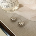 Detailed view of silver minimalist C-shaped hoop earrings on elegant silk fabric - Silver