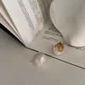 Close-up of vintage French marble earrings on a book with golden metal base detailing - White Drip Oil Ball Style