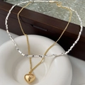 Dettaglio della collana a doppio strato con ciondolo a cuore su vassoio in ceramica - Collana a Doppio Strato Con Pendente a Cuore Metallico