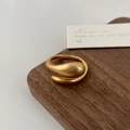 Detailed close-up of matte gold fluid teardrop ring on dark wood background - Matte Gold Irregular Staggered Ring
