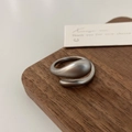 Detailed macro view of matte silver open ring with irregular fluid design on wood stand - Matte Silver Irregular Staggered Ring