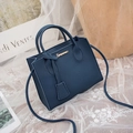 Navy blue lychee texture crossbody bag with gold logo on elegant white lace background - Blue
