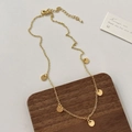 Detalle de la cadena minimalista de oro de 18K con cinco pequeños dijes de discos - Colgante de moneda / Dorado