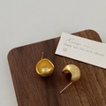 Detail of gold bean earrings with brushed matte finish on a wooden display board - Gold Teardrop Style