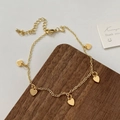 Detalle de pulsera dorada con dijes de corazón, cadena fina y cierre de mosquetón - Corazón dorado (D-82)