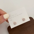 Macro shot of rose gold round stud earrings with pave-set cubic zirconia on display card - Rose Gold