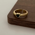 Dettaglio della pietra nera a cuore e della fascia dorata testurizzata regolabile - Anello d'oro con zircone nero