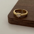 Dettaglio dell'anello croissant dorato con zircone a cuore su espositore in legno - Anello Zircone Bianco Oro