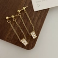 Macro shot of long gold tassel earrings with micro-set zircon on dark wood surface - Gold White Stud Style (A-202)