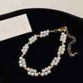 Detail eines zweireihigen Perlenarmbands mit Goldperlen und verstellbarem Karabinerverschluss - Elegantes Perlenarmband