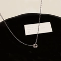 Detailaufnahme einer silbernen Halskette mit rundem Geflecht-Anhänger auf schwarzem Tablett - Ring Anhänger Halskette / Silber (Echt Vergoldetes Kupfer)