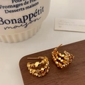 Detailaufnahme mehrlagiger goldener geometrischer Perlenohrringe auf dunklem Holz - Gold