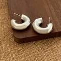 Dettaglio di orecchini a cerchio a C argentati su sfondo di legno e iuta - Orecchini a C da 2.5cm Argento