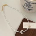Detailed shot of oval pearl necklace with crescent shell pendant and lobster clasp detail - High Bright Pearl Style