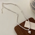 Détail d'un collier de perles avec pendentif cœur argenté sur planche en bois - Style Coeur Argenté (B-316/12#)