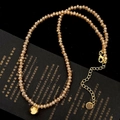 Detailed macro of amber faceted glass beads necklace with golden bell and lobster clasp - Champagne Crystal Necklace