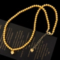 Detail of golden pearl necklace with sphere pendant and adjustable extension chain - Gold Pearl Necklace