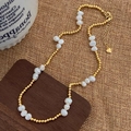 Dettaglio di collana con perle d'acqua dolce, perline dorate e ciondolo a cuore - Collana / Oro