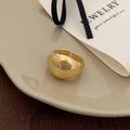 Macro view of a gold-plated teardrop ring with high-polished finish on beige porcelain - Thick Dome Open Style / Gold