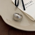 Close-up of polished silver wide dome ring on ceramic plate with elegant aesthetic - Thick Dome Open Style / Silver