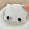 Macro view of silver heart-shaped earrings with black zircon stones on a white card - Silver Black Zirconia