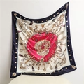 Close-up of luxury silk scarf with vintage key and tassel patterns in navy and red - Navy Blue Edge