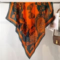 Orange silk scarf with dark green vintage floral patterns on a hanging display - Orange Green Floral (FE143-1) / 110X110CM