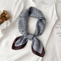 Détail d'un foulard en soie vintage à motif paisley bleu brume sur une robe en satin - Bleu Morandi