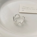 Detailed close-up of a minimalist silver wavy irregular ring on a white ceramic tray - Irregular Wave Style (C-194) / Silver