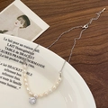 Dettaglio del ciondolo di perle barocche vintage con zircone su un piatto decorativo - Collana di Perle d'Acqua Dolce Con Ciondolo in Zirconia Argentata
