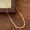 Gros plan détaillé du collier de perles d'eau douce avec perles dorées et fermoir homard - Collier de perles d'eau douce