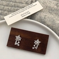 Detailed close-up of sparkling star-shaped stud earrings with zircon meteor trail on wood - Stud Earrings (Pair) / Silver Paved Star Stud Earrings
