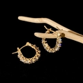 Primer plano de pendientes de aro dorados con circonitas sobre fondo de madera - Pequeño / Oro con Circonitas Completas