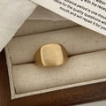 Macro detail of golden brushed metal ring with a cushion shape on a premium gift box - Gold Tinsel Style