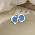 Detailed close-up of oval cat-eye stone earrings with silver-tone metal framing on tray - Silver Edge Blue Cat Eye