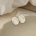 Detail of silver oval vintage earrings with cat eye stones on a ceramic plate - Silver Edge White Cat Eye