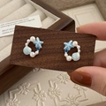 Close-up of starfish and shell earrings with blue enamel and white pearls details - Blue Starfish Earrings