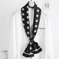 Detail of a black silk scarf with white daisy print tied around a white collar blouse - Black Daisy