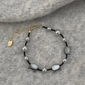 Detailed shot of cat shell beads and grey pearls on a handcrafted bracelet with gold clasp - Grey Pearl Cat Bracelet