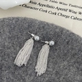 Vista macro de pendientes largos con borlas plateadas y perlas grises sobre fondo textil - Pendientes de Borla de Perla Gris(A-825) / Perla Gris Plata
