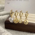 Détail macro de quatre boucles d'oreilles dorées avec pendentifs en zircon sur carte - Ensemble de 4 Boucles d'Oreilles Créoles Dorées