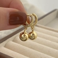 Vue macro de boucles d'oreilles boules en or 18 carats avec finition miroir polie - Pendentif Boule Lisse Dorée