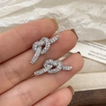 Detailansicht der silbernen Knotohrringe mit fein gefassten Zirkonia Kristallen - Knoten-Stil / Silber