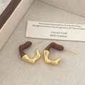 Dettaglio ravvicinato di orecchini a C geometrici irregolari con finitura oro e smalto marrone - Marrone (Rame Placcato in Oro Vero)