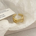 Macro-detail van een geometrische gouden open ring met modern kruisend ontwerp - Gouden Geometrische Lijnstijl (C-337) / Goud